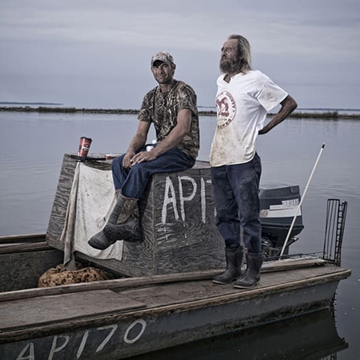 Where Have All the Oysters Gone? 1 Roscoe Rotella, 34, (left) and Terry Nowling, 50, relax on their oyster boat after a day of oystering on the Apalachicola Bay. Both men have been catching oysters for their entire lives. (Photo by Jeremiah Stanley)