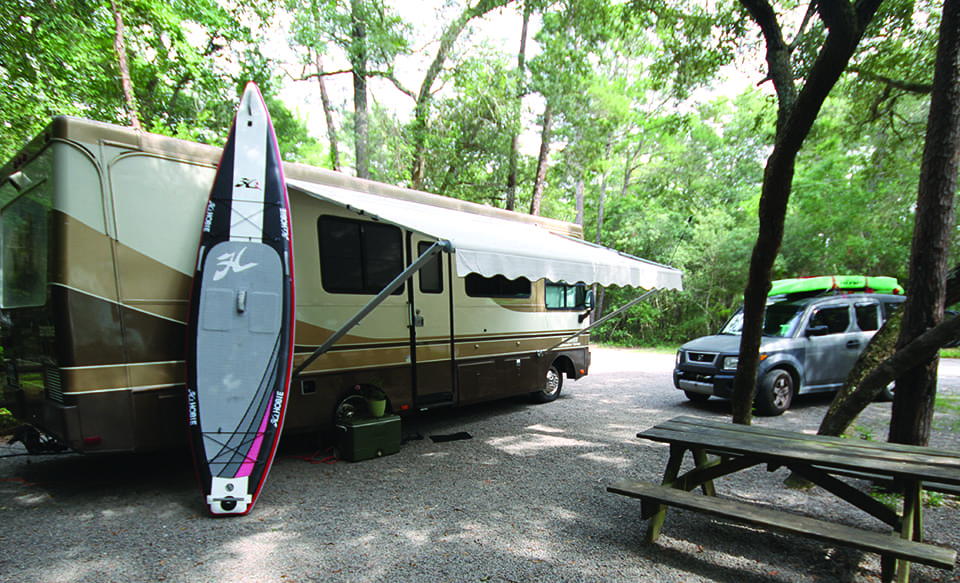 My Florida: Ramble On 3 The author’s camper and paddleboard, essential items for outdoor Florida adventures; Photograph by Kevin Mims