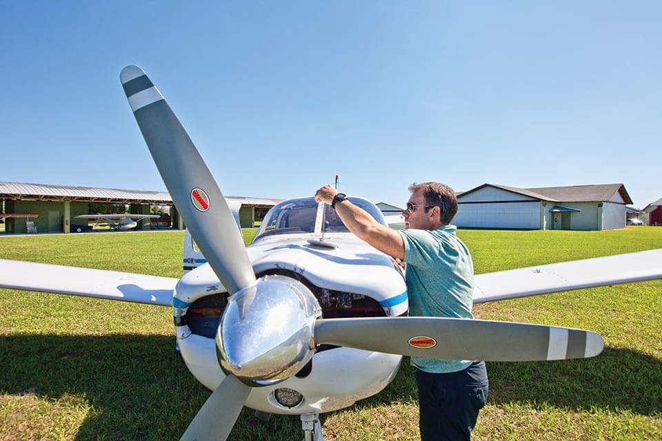 Sky’s the Limit in a Small-Craft Airplane 5 Jamie Clifford checks the oil level in his plane before take off. Photograph by Jeremiah Stanley