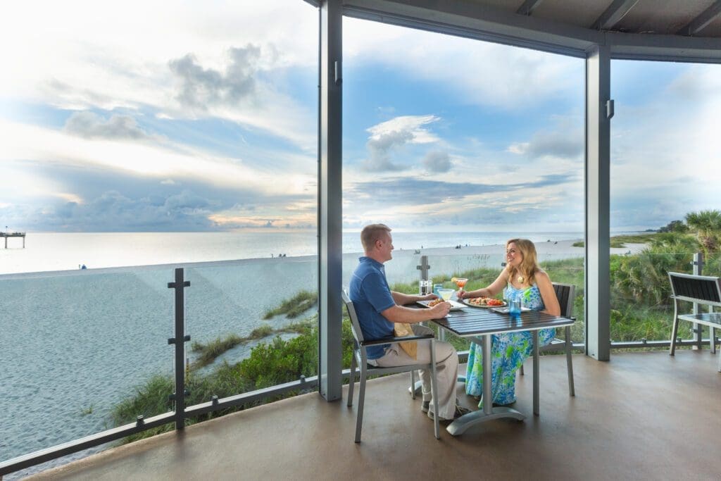 Two diners, a man and woman, enjoy a beachfront meal in Savor Sarasota. 