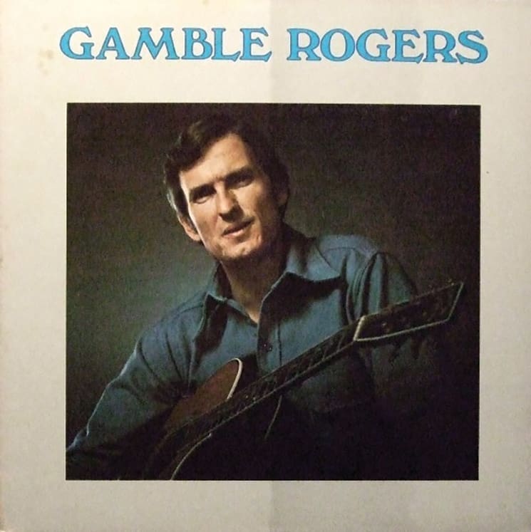 A '70s album cover. A neutral backdrop with blue, all-caps text that reads Gamble Rogers across the top. A shadowy, square portrait of the musician holding his guitar is in the center.