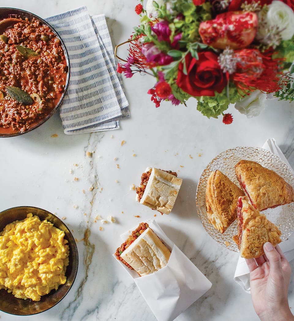Gasparilla Brunch (clockwise): scrambled eggs, picadillo, guava tarts, picadillo on cuban bread; Photography by Jessie Preza; Flowers by Mardee Morris