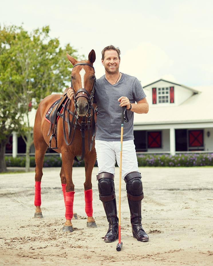 Brandon Phillips smiles with his pony, Honey Badger. They stand in the dirt. Phillips has his arm under Honey Badger's neck.