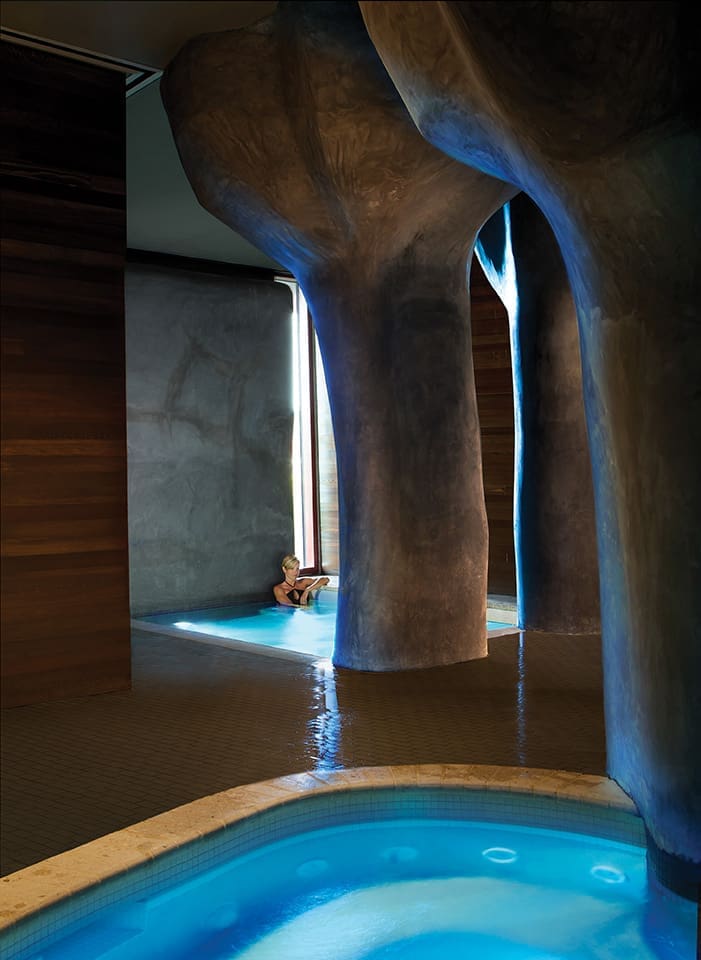 Inside the spa, “petrified tree” columns surround the seven pools.