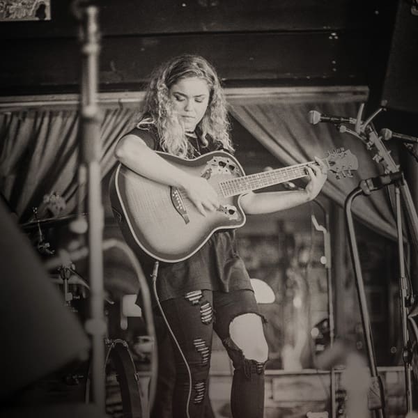 Singer-songwriter for Fledglings Claire Vandiver holds a guitar.