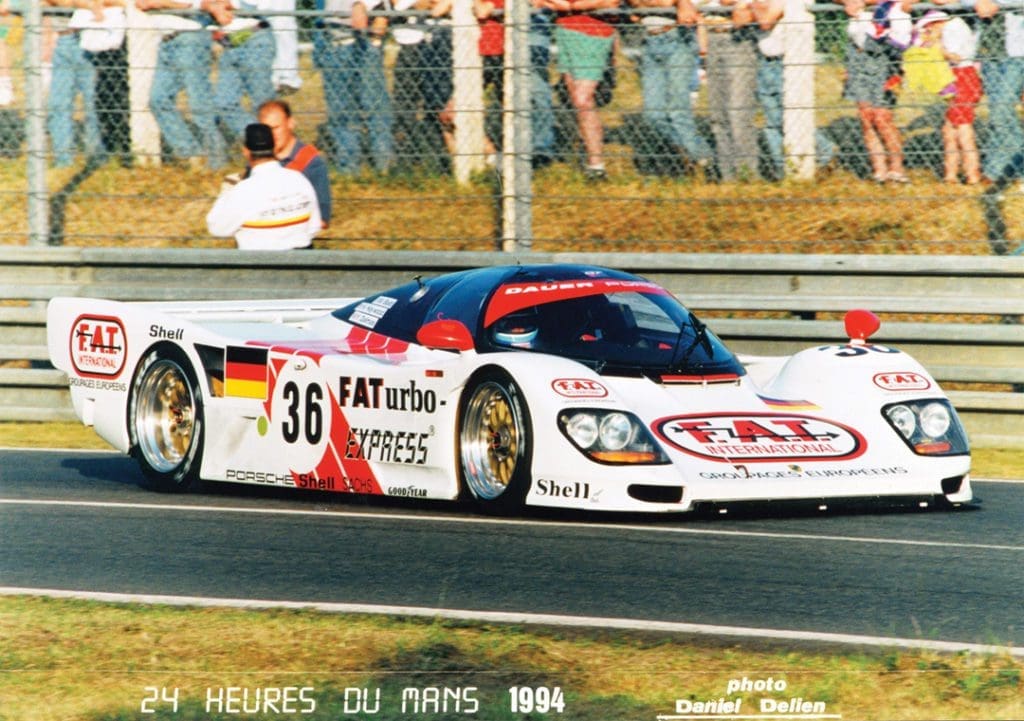 Racing Icon Hurley Haywood Gets Real About His Personal Life & Career 11 Haywood in a white car with various ads. It doesn't have the stripes of his earlier car.