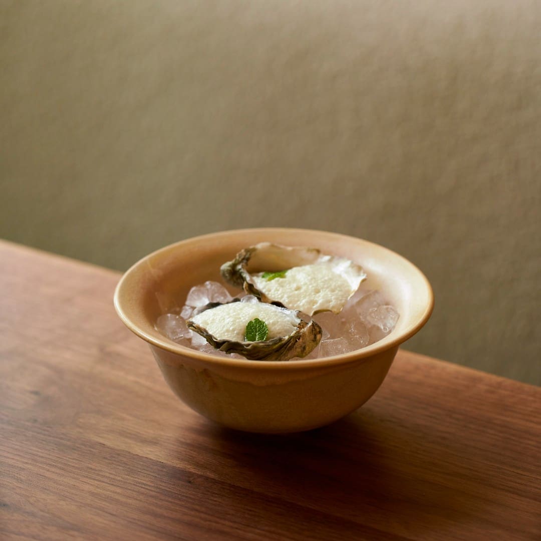 two oysters in a bowl sitting on a table