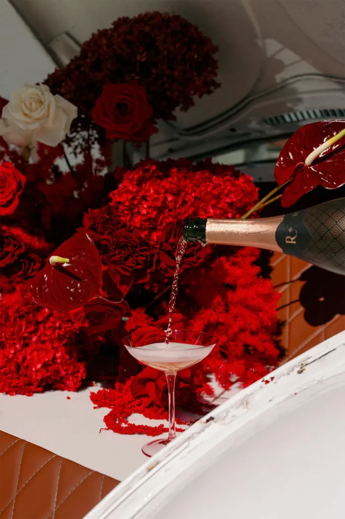 These Two Professional Partiers Are Raising the Bar (Car) 4 A glass of bubbly wine being poured inside the Betty Boujee pop-up bar.