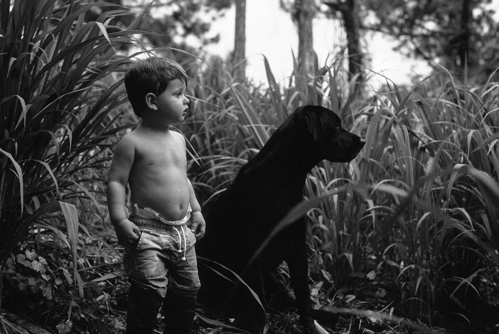 A Wild Florida Childhood Captured on Camera 6 a toddler and a black Lab puppy