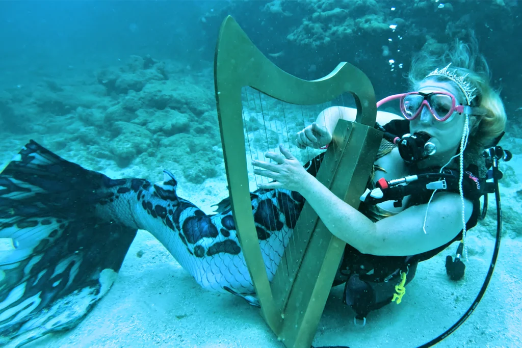 What to do this July in Florida 8 Mermaid plays harp underwater.