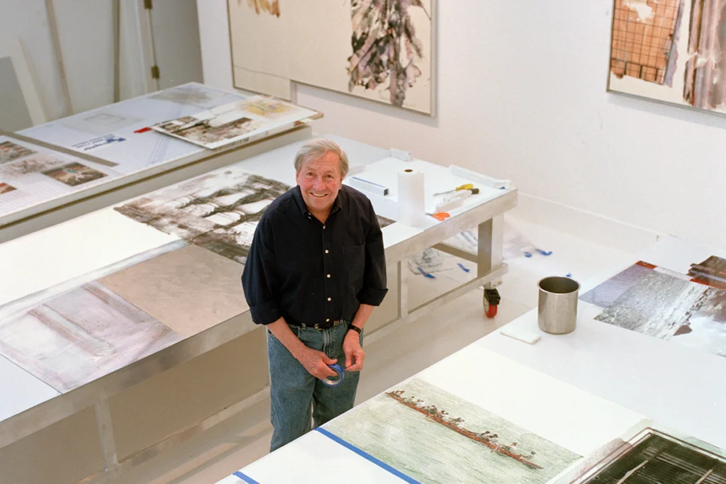 Bob Rauschenberg standing in his gallery.